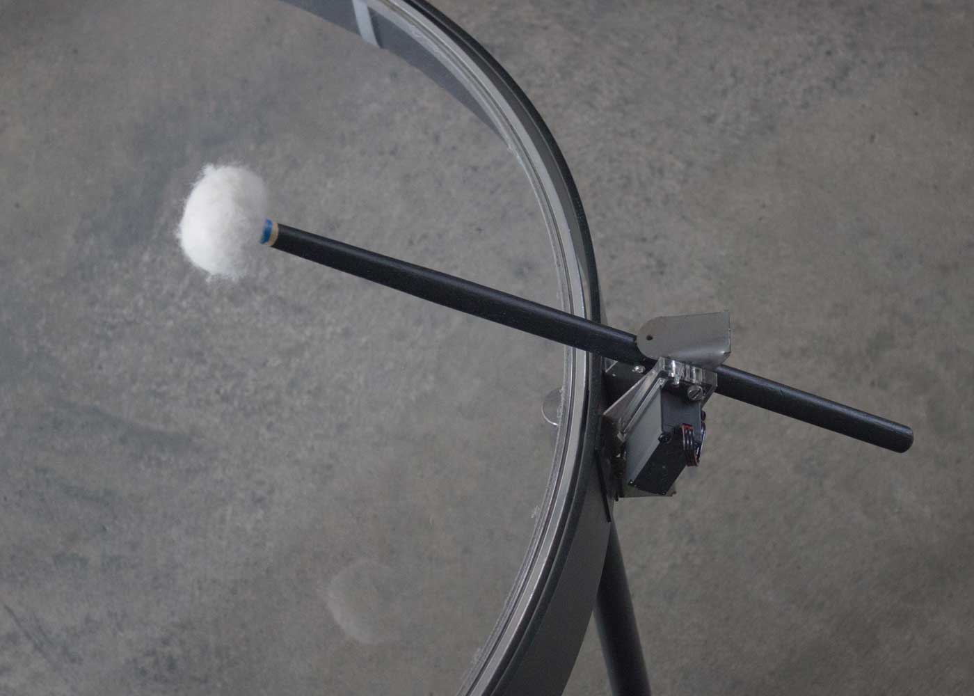 A closeup of a mallet striking the drum.