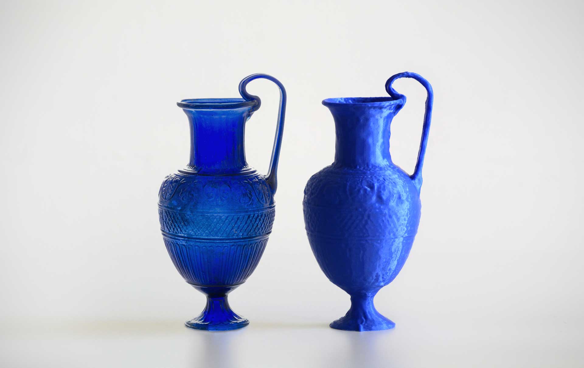 The original blue jug beside a 3D-printed replica.