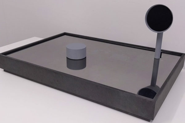 A low black box supporting a grey puck and a grammophone style speaker horn.